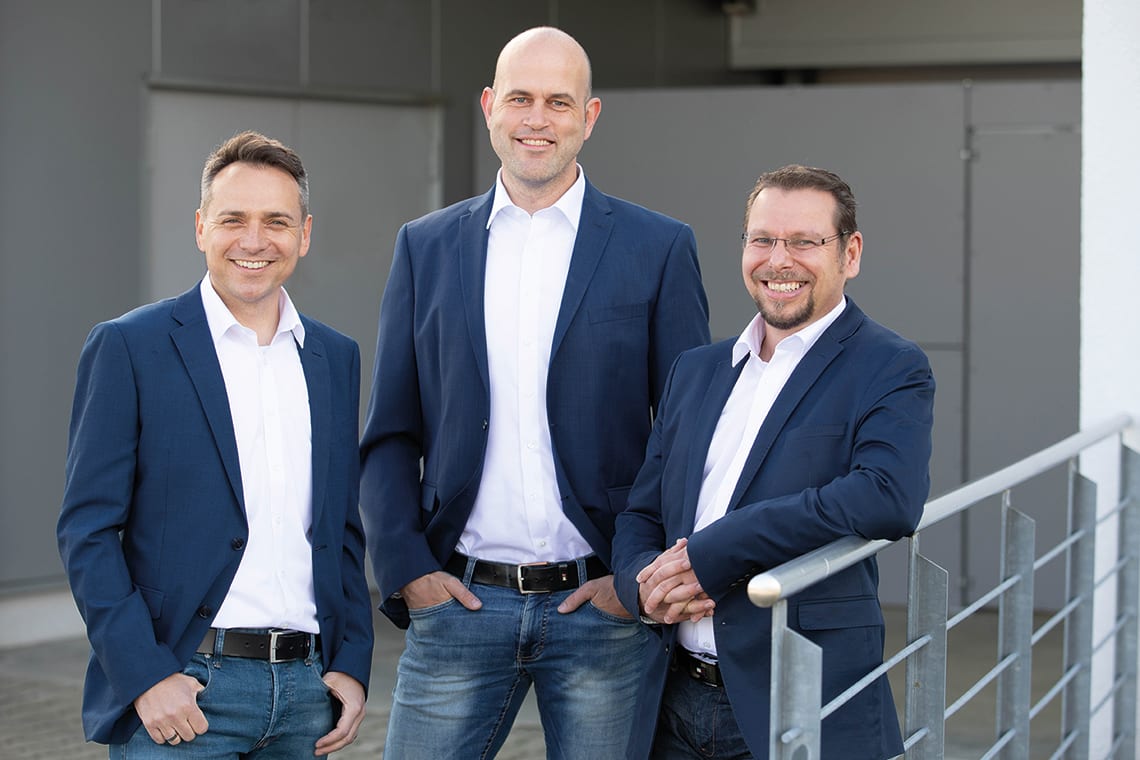 Die drei Geschäftsführer Michael Staggat, Patrik Pintacuda und Wolfgang Klink der PWM Technology Group vor dem Eingang in das Firmengebäude in Bodnegg